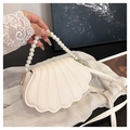 Detail van schelpvormige witte leren tas met parelhandvat en geribbelde stiksels - Wit