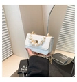 Dettaglio del manico di perle e chiusura dorata su borsa bianca con trama coccodrillo - Bianco