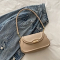 Minimalistische beige Umhängetasche mit goldener Schnalle und Kettenträger auf Denim - Khaki