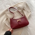 Bolso baguette de cuero mate burdeos con hebilla dorada en H sobre fondo de blazer beige - Burdeos