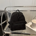 Minimalist black corduroy mini backpack for women featuring vertical texture and dual zippers - Black