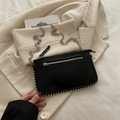 Black vintage textured shoulder bag with silver studs and chain strap on beige blazer - Black