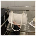Detail of white crocodile pattern shoulder bag with gold hardware and PU leather texture - White