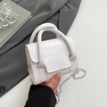 Mini borsa bianca in ecopelle a coccodrillo con tracolla a catena d'argento in mano - Bianco