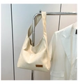 Detalle del bolso tote beige de piel sintética con bolsillo frontal y etiqueta de cuero marrón - Blanco
