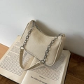 Chic beige woven crescent bag with chunky chain strap on a vintage book - Khaki