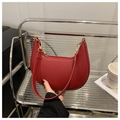 Dettaglio della borsa a mezzaluna rossa con texture litchi e zip in metallo dorato - Rosso