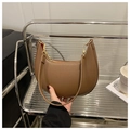 Coffee brown leather crescent bag with gold hardware shown in a hand-held lifestyle setting - Brown