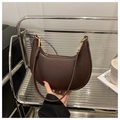 Dettaglio borsa a mezzaluna in pelle marrone con zip dorata e fodera rossa - caffè