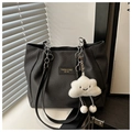 Detalle del bolso tote negro con textura de espiga y un colgante de peluche suave - Negro Con Colgante