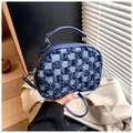 Dettaglio macro della borsa rotonda in denim blu con trama a scacchi e bordi sfrangiati - Blu scuro