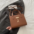 Sac à main marron en cuir litchi avec pendentif cerf sur un costume gris - Marron