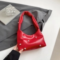 Red half-moon shoulder bag with silver studs and pleated handle in a chic setting - Red