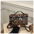 Detail of leopard print crossbody bag with silver zippers and textured top handle - Brown