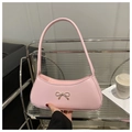 Nahaufnahme der rosa Schultertasche mit Metallschleife und schmalem, flachem Griff - Rosa