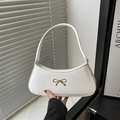 White faux leather crescent shoulder bag with golden bow hardware and zipper closure - White