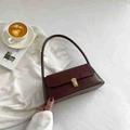 Vintage bordeauxrote Leder-Baguette-Tasche mit goldener Schnalle in Lifestyle-Anordnung - Braun