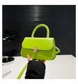 Detailed view of neon green mini crossbody bag with metal twist lock and top handle - Green
