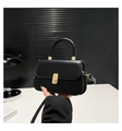 Detail of black baguette bag featuring gold twist lock and sleek leather finish - Black