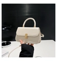 Close-up of cream leather baguette bag featuring a gold rectangular metal clasp and handle - White