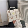 Nahaufnahme der cremeweißen Tasche mit Faltenstruktur und bunten Cartoon-Stickereien - Gebrochenes Weiß
