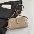 Bolso de hombro de cuero beige minimalista con hebilla dorada en un elegante entorno - Caqui