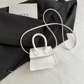 Petit sac à main blanc minimaliste en cuir avec bandoulière sur costume noir - Blanc