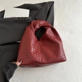 Minimalist woven hobo bag in deep burgundy faux leather with a chic knotted handle - Red