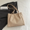 Minimalistische kaki geweven tote bag met schouderriem op een zwarte blazer - Khaki