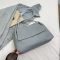 Borsa tote intrecciata grigio-azzurra con tracolla a catena su giacca denim - Blu