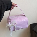 Detail einer hellvioletten Handtasche mit weißer Spitze und Perlen-Schleifen-Accessoire - Mit Anhänger / Lila