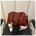 Detail of burgundy glossy leather handbag with gold metal hardware and buckle decoration - Red