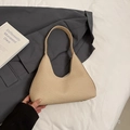 Chic beige woven crescent shoulder bag on dark gray blazer with modern lifestyle aesthetic - Khaki