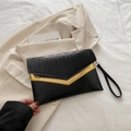 Elegante bolso sobre negro con borde de metal dorado y textura de ondas sutiles - Negro