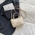 Schicke beige Stroh-Handtasche mit Lederriemen auf minimalistischem weißem Grund - Gebrochenes Weiß