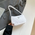 Chic white pleated shoulder bag with a silver butterfly emblem on grey jacket - White