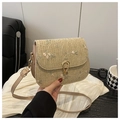 Close-up of woven straw bag with floral embroidery and golden metal buckle clasp detail - Khaki