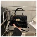 Dettaglio borsa a mano vintage nera con trama stropicciata e chiusura girevole oro - Nero
