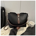 Detail of minimalist black bucket bag with brown leather straps and silver twist lock closure - Black