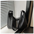 Close-up of black leather tote bag with lychee grain texture and silver hardware details - Black