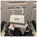 Detail of white PU leather handbag with gold bow and decorative knotted handle - White