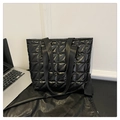 Vista detallada del bolso tote acolchado negro con bordado de rombos y acabado brillante - Negro