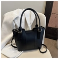 Close-up of black leather tote bag with vertical stitching and light gold hardware detail - Black