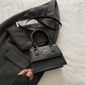 Elegante borsa a mano in pelle nera opaca con fiocco dorato e tracolla regolabile - Nero