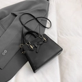 Sac à main noir en similicuir avec détail nœud, touches dorées et bandoulière réglable - Noir
