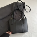 Borsa tote minimalista in pelle nera con dettagli dorati e tracolla regolabile - Nero
