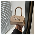 Detail of elegant beige crossbody bag with silver bow buckle and metal chain strap - Khaki