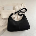 Minimalistische schwarze matte Hobo-Tasche mit verstellbarem Riemen auf beigem Blazer - Ohne Anhänger / Schwarz