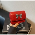Détail du mini sac rouge en cuir huilé avec nœud argenté et fine bandoulière - Bordeaux