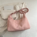 Rosafarbene Hobo-Tasche aus Mattleder mit breitem Gurt auf weißem Blazer und Buch - Ohne Anhänger / Rosa